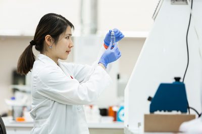 staff observing micronutrient hemp sample in test tube